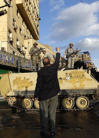 A protester raises his fist in front of an army armoured personnel carrier in Cairo's Tahrir Square